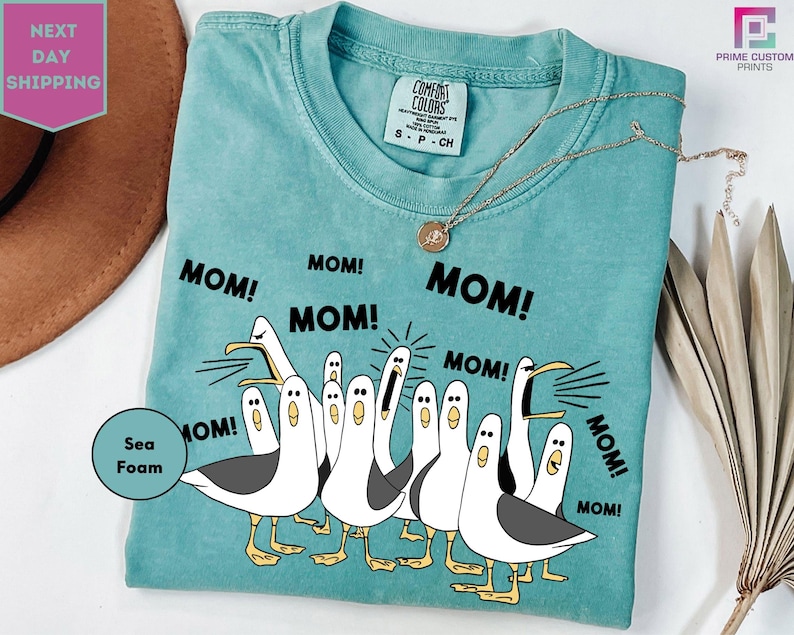 a woman wearing a t - shirt with three geese saying mom, mom, mom