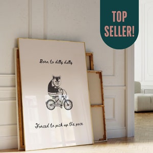 May include: A black and white illustration of a bear riding a bicycle with the text "Born to dilly dally, Forced to pick up the pace".