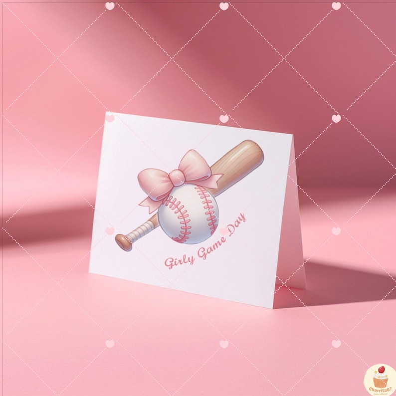 May include: A white card with a pink bow on a baseball bat and a baseball. The text on the card says "Girly Game Day".