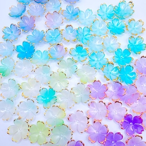 May include: Assortment of pastel colored flower shaped resin beads with gold trim. The beads are in shades of purple, blue, green, and pink.