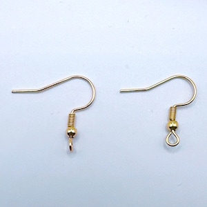 May include: Two gold-colored earring hooks. Each hook has a curved wire for the ear, a coiled spring, a small bead, and a loop or a small hook at the bottom for attaching a charm or bead. The hooks are on a white background.