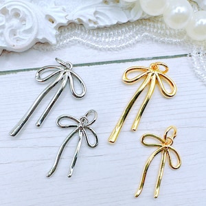 May include: Four metal bow charms, two gold and two silver, with a loop at the top for attaching to jewelry or other crafts.