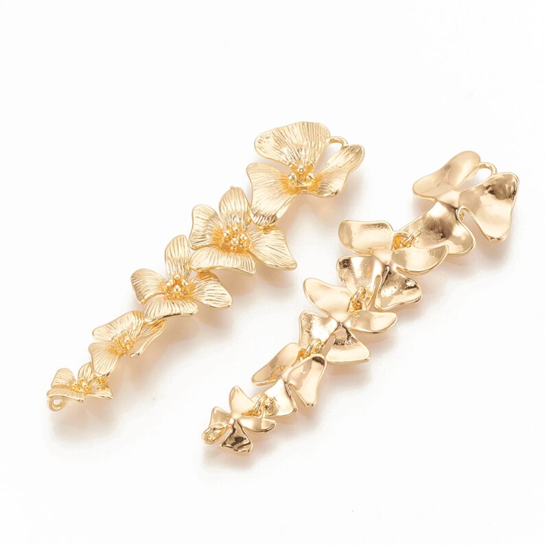 May include: A pair of gold-tone earrings with a floral design. Each earring features a chain of interconnected flower-shaped charms.