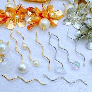 May include: A collection of gold and silver wavy headpins with pearl and iridescent beads. The headpins are perfect for jewelry making and crafting.