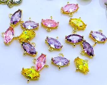 Può includere: Assortimento di ciondoli in cristallo colorati a forma di marquise con montature dorate. Ogni ciondolo ha due anelli per il fissaggio ai gioielli.