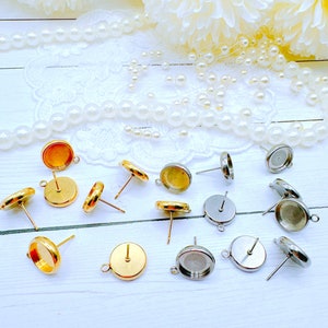 May include: Assortment of gold and silver earring settings. The settings are round and have a post for attaching earrings.