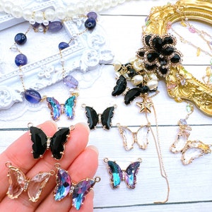 May include: Assortment of butterfly-shaped charms with crystal and black accents. The charms are gold-toned and have a loop for attaching to jewelry or other crafts.