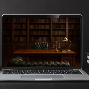 May include: A laptop screen shows a traditional law office interior with a wooden desk, leather furniture, and a bookcase. A grey mug and a stack of books are next to the laptop. A gold lamp and scales are on the desk.