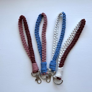May include: Four crocheted keychains with metal rings. The keychains are made with different colored yarn: burgundy and blue, pink and blue, white and burgundy, and white and blue.