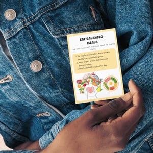 May include: A yellow card with the text "Eat Balanced Meals" and a list of tips for eating healthy. The card has illustrations of balanced meals with a variety of foods.