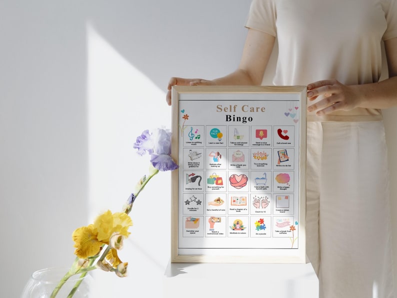 May include: A printable self-care bingo card with a white background and colorful illustrations. The card has 25 squares with different self-care activities, such as taking a bath, listening to music, and reading a book. The title of the card is "Self Care Bingo".