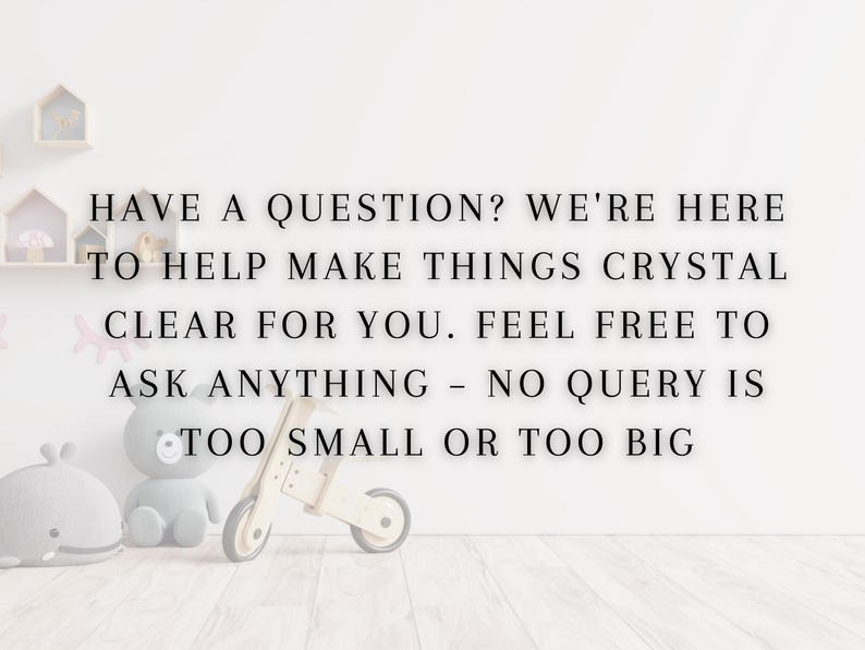 May include: A white wall with black text that reads "HAVE A QUESTION? WE'RE HERE TO HELP MAKE THINGS CRYSTAL CLEAR FOR YOU. FEEL FREE TO ASK ANYTHING - NO QUERY IS TOO SMALL OR TOO BIG". There are toys in the foreground, including a wooden toy scooter, a gray stuffed animal, and a blue stuffed whale.
