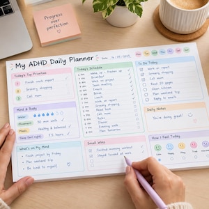May include: A rectangular daily planner notepad titled My ADHD Daily Planner with pastel-coloured sections for priorities, schedule, to-do list, mind and body tracking, notes, small wins, and mood icons. The paper features printed text and checkboxes.