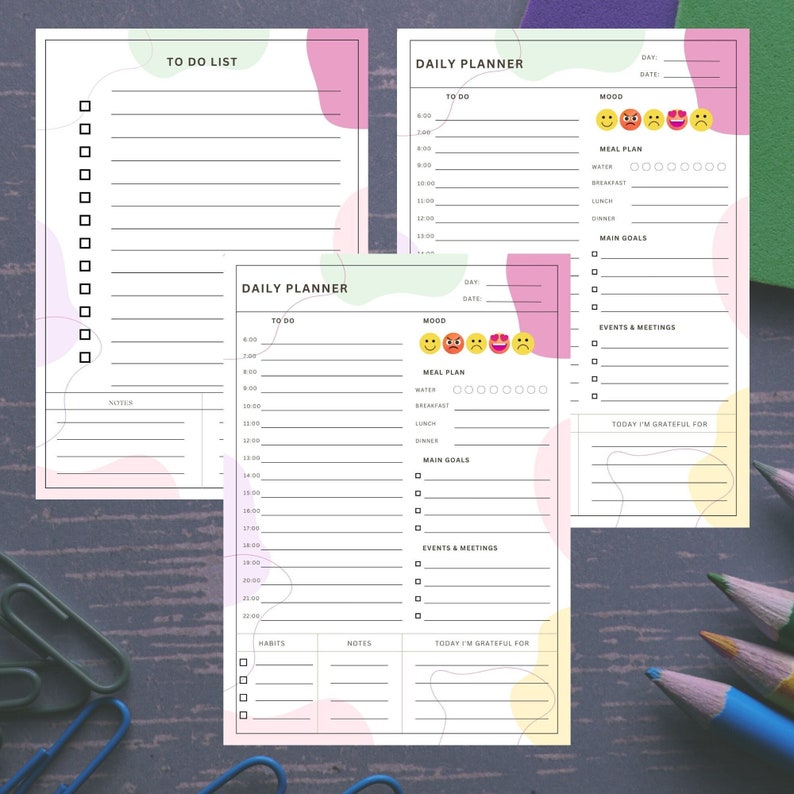 Op de afbeelding: Een printbare dagelijkse planner met secties voor takenlijsten, stemmingstracking, maaltijdplanning, hoofddoelen, evenementen en vergaderingen, en dankbaarheid. De planner heeft een lichtgroen, roze en geel kleurenschema met abstracte vormen.