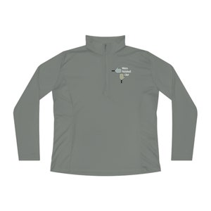 May include: A gray long-sleeve performance shirt with a zippered neck. The shirt has a small embroidered logo on the left chest that says "Mitten Pickleball Club" and features a pickleball paddle and ball.