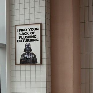 May include: A framed poster with a black and white image of Darth Vader from Star Wars. The poster says "I find your lack of flushing disturbing."