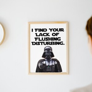 May include: A framed print with a black and white image of Darth Vader from Star Wars. The text on the print reads "I find your lack of flushing disturbing."