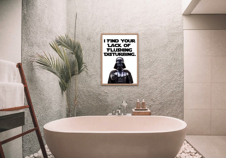 May include: A bathroom with a white bathtub and a framed print of Darth Vader saying "I find your lack of flushing disturbing."