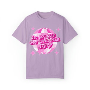May include: A lavender t-shirt with a pink disco ball graphic and the text "Do you guys ever think about Dying?" in a pink retro font.