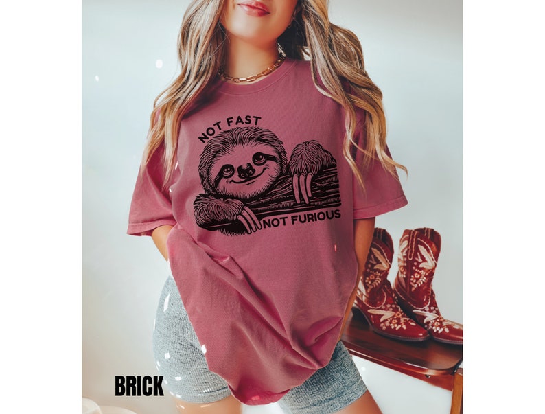 May include: A maroon t-shirt with a black graphic of a sloth and the text "Not Fast Not Furious".