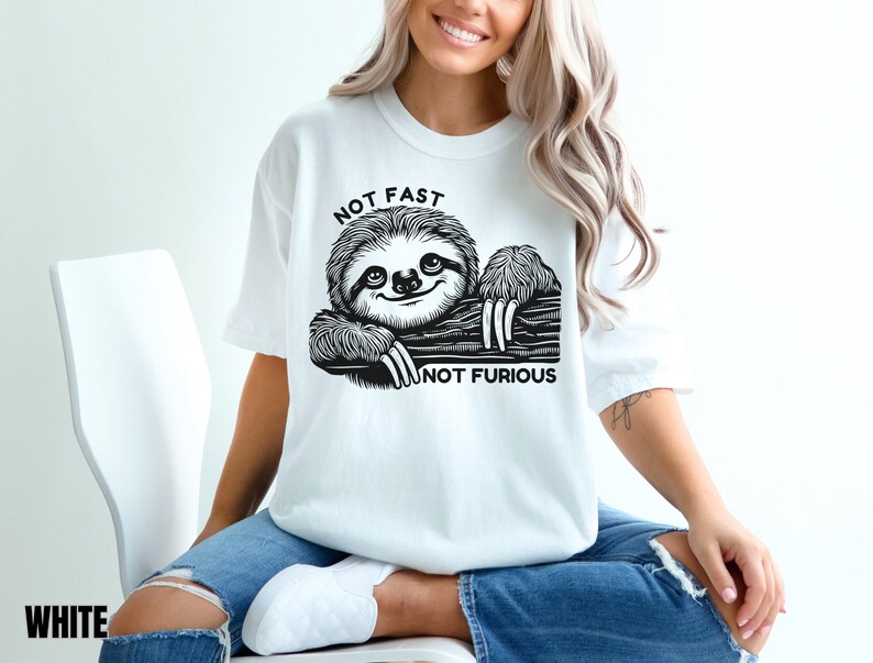 May include: White t-shirt with a black and white illustration of a sloth with the text "Not Fast Not Furious".