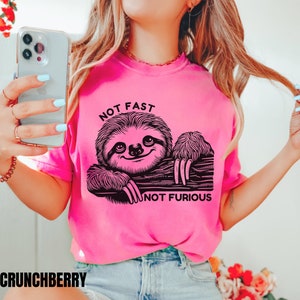 May include: Pink t-shirt with a black sloth graphic and the text "Not Fast Not Furious".