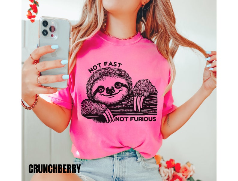 May include: Pink t-shirt with a black sloth graphic and the text "Not Fast Not Furious".