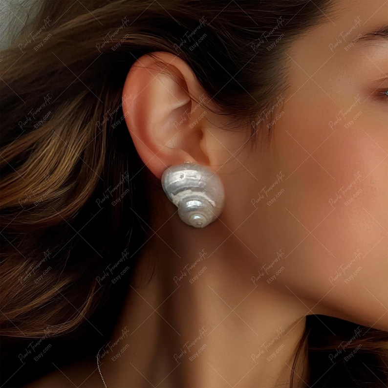 Puede incluir: Un par de pendientes grandes de perlas barrocas blancas. Las perlas tienen forma de concha y un brillo natural iridiscente.