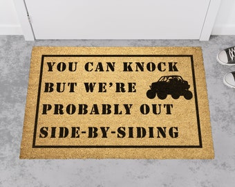 Może przedstawiać: Brązowa wycieraczka do drzwi z tekstem "You can knock but we're probably out side-by-siding" i sylwetką pojazdu typu side-by-side.