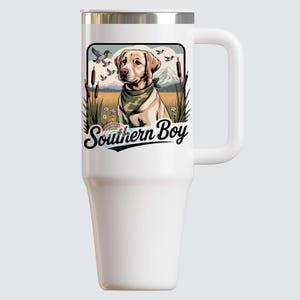 Op de afbeelding: Witte ge&iuml;soleerde beker met een handvat en een zilveren rand. De beker heeft een afbeelding van een gele Labrador met een groene bandana, met de tekst "Southern Boy". De afbeelding bevat eenden, bergen en riet.