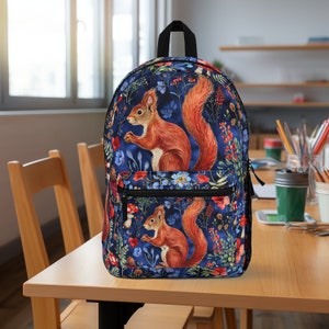 May include: A blue backpack with a floral pattern featuring red squirrels and mushrooms. The backpack has two zippered compartments and adjustable straps.
