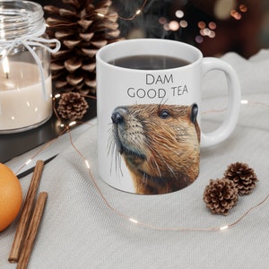 May include: White ceramic mug with a brown beaver illustration and the text "DAM GOOD TEA".