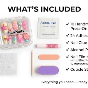 May include: A complete nail kit with the text "WHAT'S INCLUDED". The kit includes 10 handmade press-on nails, adhesive tabs, nail glue, an alcohol pad, nail file, buffer, and cuticle stick. The nails are in a clear case.