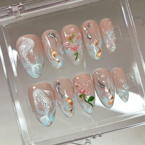 May include: A handmade wooden sign with the text "Welcome" in a playful font. The sign is painted white with a distressed finish, and features a decorative floral design in shades of pink and green. It measures approximately 12 inches wide.