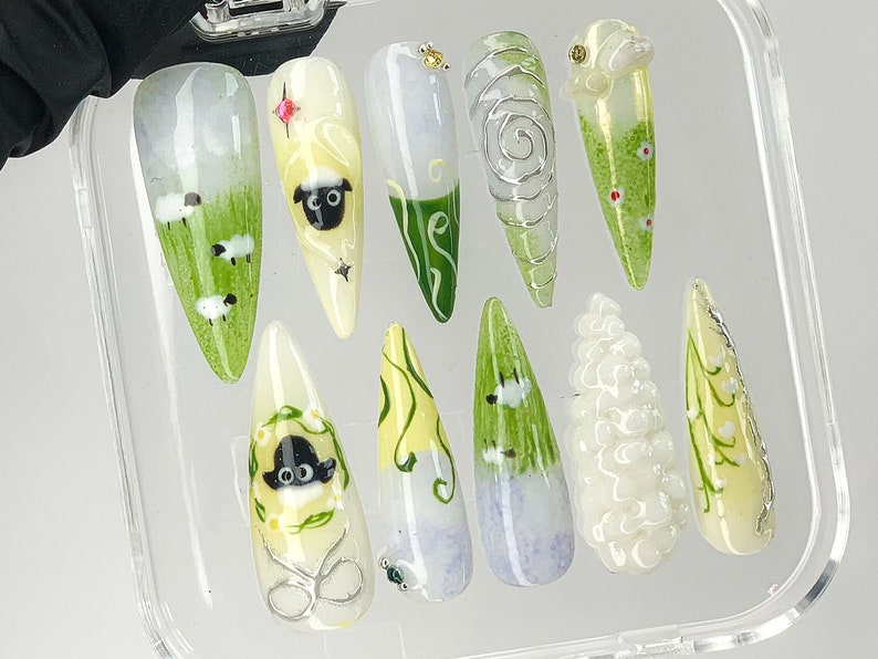Puede incluir: Un juego de tres tazas de cer&aacute;mica con un esmalte moteado de color crema. Cada taza presenta un dise&ntilde;o pintado a mano diferente: una hoja verde, una flor azul y un sol amarillo. Las tazas tienen un dise&ntilde;o simple y moderno.