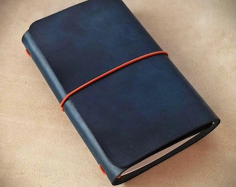 Refillable trifold leather traveler's journal, featuring burnished edges and a durable elastic closure