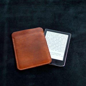 Puede incluir: Un juego de tres tazas de cerámica con un acabado mate moteado. Las tazas son de color crema, marrón claro y marrón oscuro. Cada taza tiene un diseño simple y minimalista y un asa redondeada.