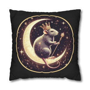 May include: A black throw pillow with a graphic of a rat wearing a gold crown and holding a scepter. The rat is sitting on a crescent moon with a starry background.