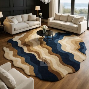 May include: A modern living room featuring a large, round rug with a wavy pattern in shades of blue, beige, and brown. The room includes two cream-colored sofas, a black coffee table, and a crystal chandelier. The floor is made of wood.