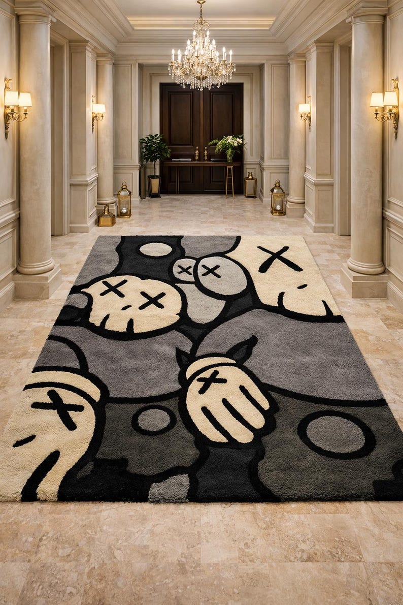 K&ouml;nnte beinhalten: Ein rechteckiger Teppich mit einem verspielten Design. Der Teppich zeigt ein Muster aus cartoonartigen Figuren in Grau-, Schwarz- und Cremet&ouml;nen. Die Figuren haben X-f&ouml;rmige Augen und H&auml;nde mit Kreuzen. Der Teppich befindet sich in einem gro&szlig;en Eingangsbereich.