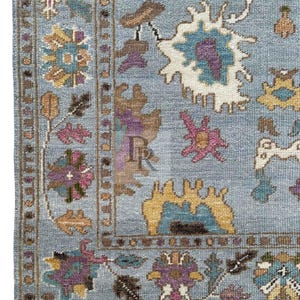 K&ouml;nnte beinhalten: Ein blauer Teppich mit traditionellem persischem Design. Der Teppich zeigt komplizierte Blumenmuster in den Farben Rosa, Gelb und Braun.