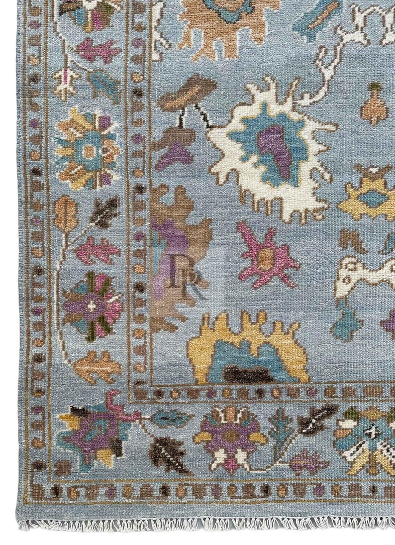 K&ouml;nnte beinhalten: Ein blauer Teppich mit traditionellem persischem Design. Der Teppich zeigt komplizierte Blumenmuster in den Farben Rosa, Gelb und Braun.