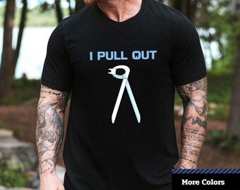 May include: A black t-shirt with the text "I PULL OUT" in blue letters and a graphic of a dental tool. The t-shirt is a unisex jersey short sleeve tee.