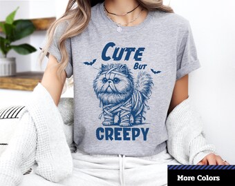 かわいいけれど不気味なハロウィン猫 T シャツ、面白い猫シャツ、かわいいハロウィンコスチューム、不気味な季節のためのユニセックス T シャツ。