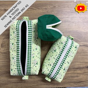 May include: Three fabric pouches featuring a light green background with a white floral pattern and green and white gingham trim. One pouch is open, one is closed, and one is a small solid dark green square pouch with a white zipper.
