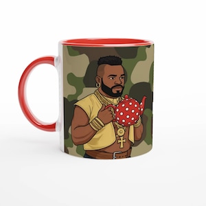 Puede incluir: Taza de cerámica con asa e interior rojos. El exterior presenta una ilustración de dibujos animados de un hombre sosteniendo una tetera roja con lunares sobre un fondo de camuflaje. La taza tiene un colgante de cruz dorada.