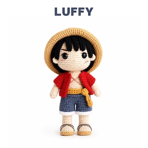 May include: A crochet doll of the character Luffy with the text LUFFY above. The doll has black hair, a tan straw hat, a red open vest, blue shorts with a yellow sash, and tan sandals. It features embroidered facial details including a small scar.