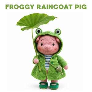 May include: A crocheted pig wearing a green frog raincoat and hood, holding a large green leaf. The pig has a pink face and is wearing green shoes. The text "FROGGY RAINCOAT PIG" is at the top of the image.