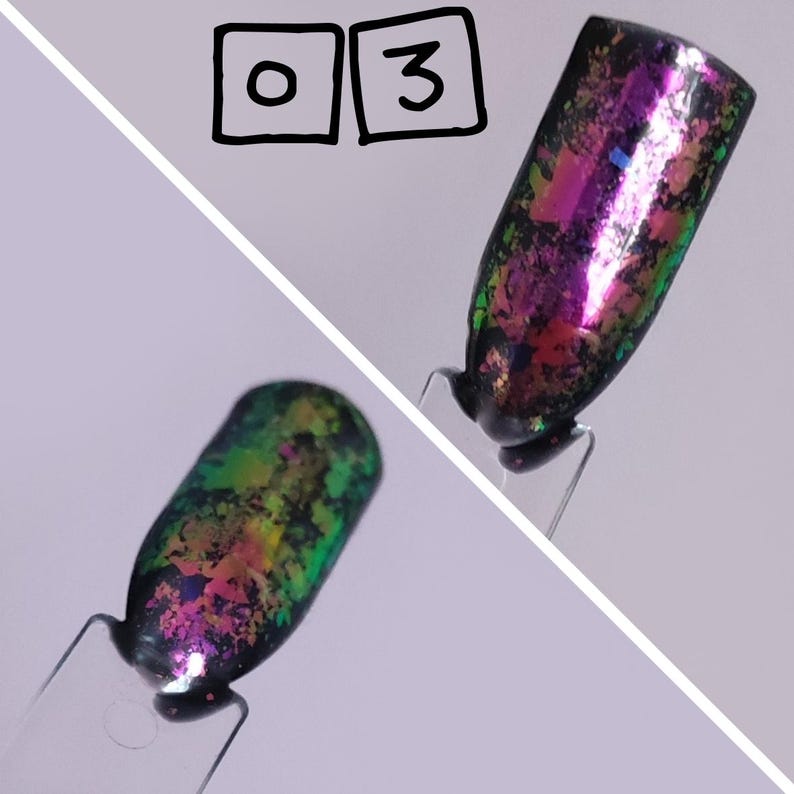 Puede incluir: Dos muestras de esmalte de u&ntilde;as en palitos de pl&aacute;stico transparente etiquetados con el n&uacute;mero 03. Las muestras presentan una base negra cubierta con escamas iridiscentes multicolores que cambian entre tonos rosa, morado, verde y dorado.