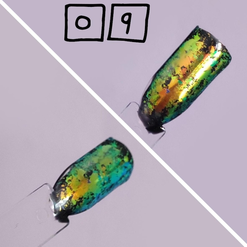 Puede incluir: Dos muestras de esmalte de u&ntilde;as en palitos de pl&aacute;stico transparente etiquetados con el n&uacute;mero 09. Las muestras presentan un acabado met&aacute;lico e iridiscente que cambia entre tonos verdes, dorados y azules con una capa oscura, moteada y texturizada.